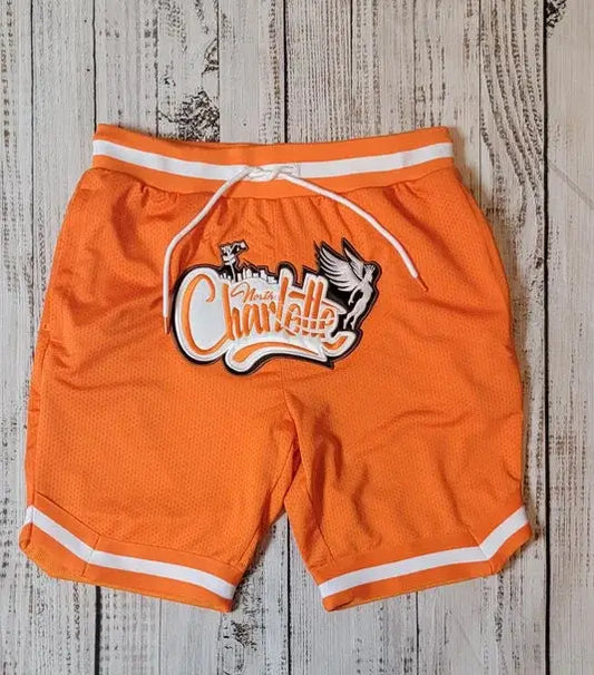 Orange shorts with a logo on a wooden surface